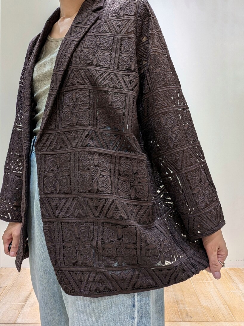 ブラウン系のテーラードジャケット、ベージュ系のタンクトップ、ブルー系のデニムパンツを着用したレディースの夏コーディネートの4枚目の写真