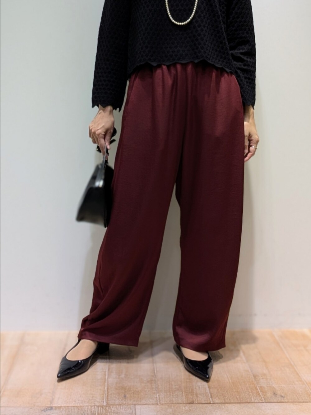 ブラック系のニット/セーター、レッド系のその他パンツを着用したレディースの秋コーディネートの3枚目の写真