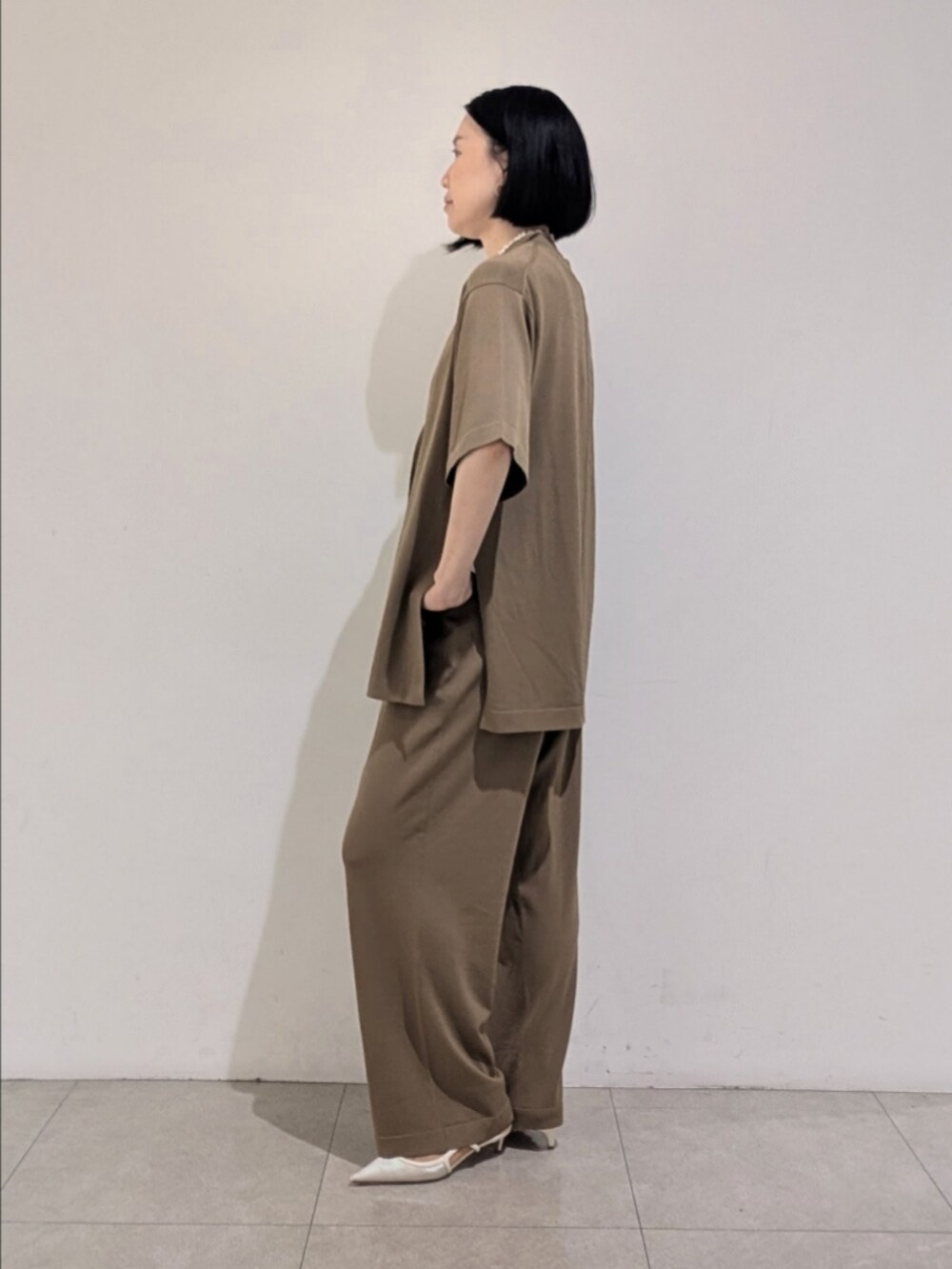 ベージュ系のその他パンツ、ベージュ系のテーラードジャケット、ホワイト系のタンクトップを着用したレディースの夏コーディネートの5枚目の写真