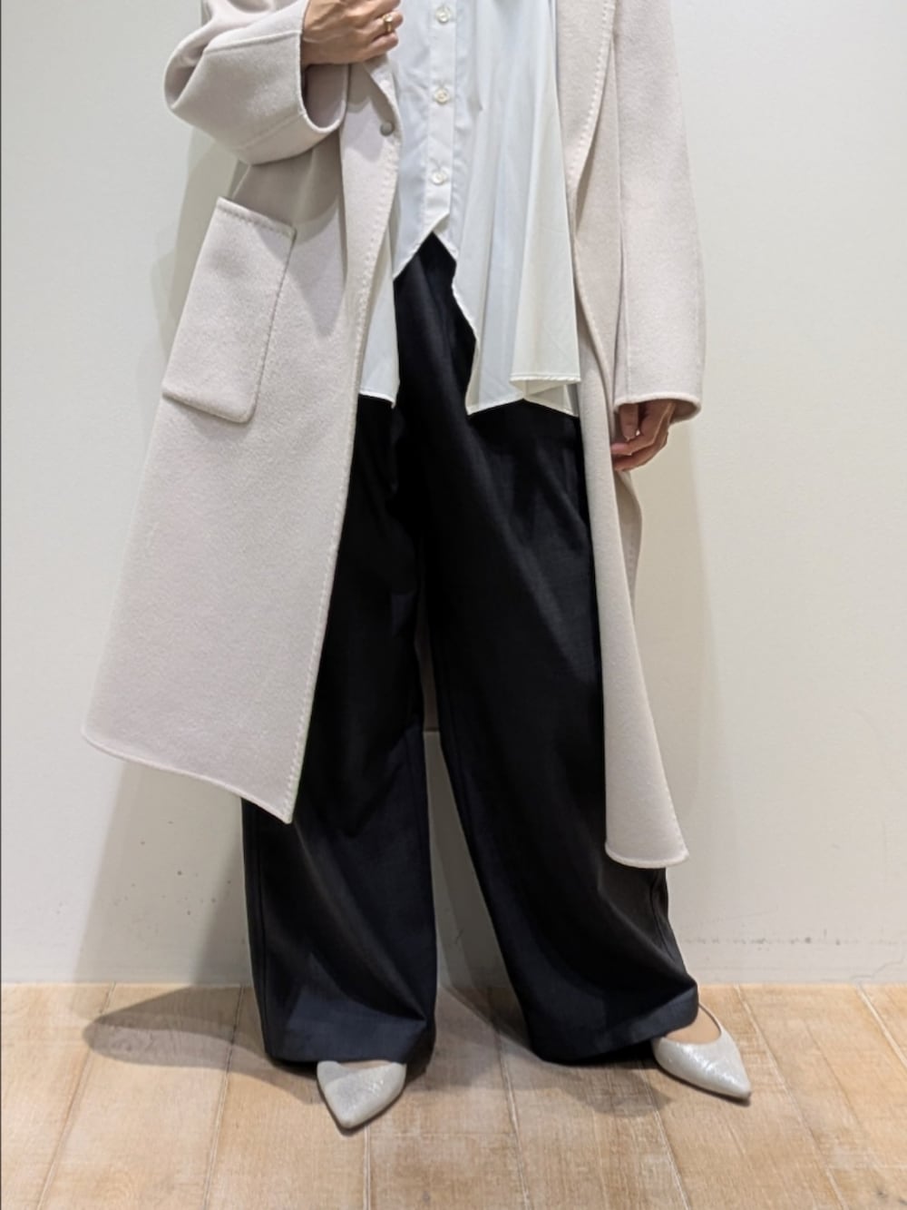 ベージュ系のチェスターコート、ホワイト系のシャツ/ブラウス、グレー系のその他パンツを着用したレディースの秋コーディネートの3枚目の写真