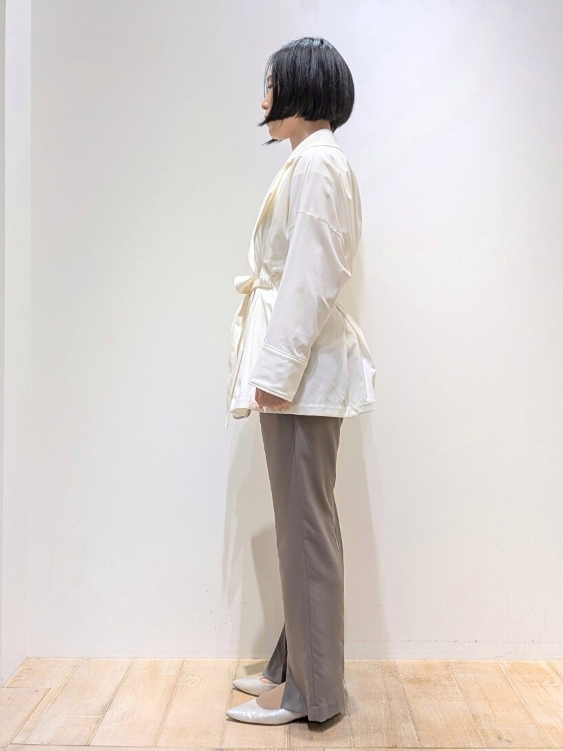 ホワイト系のトレンチコート、ホワイト系のTシャツ/カットソー、ブラウン系のスラックスを着用したレディースの春コーディネートの2枚目の写真