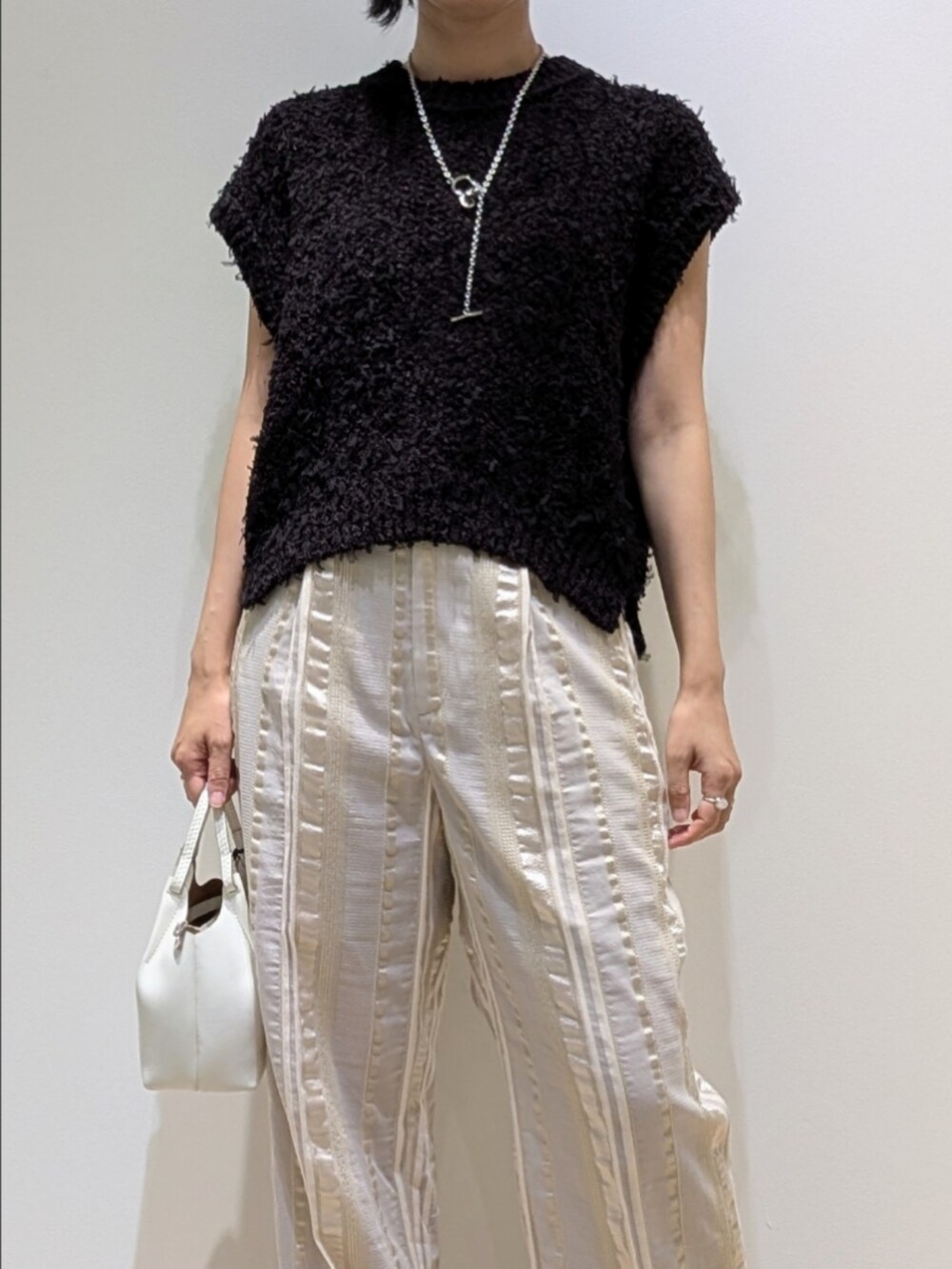 ブラウン系のニット/セーター、ベージュ系のその他パンツを着用したレディースの夏コーディネートの2枚目の写真