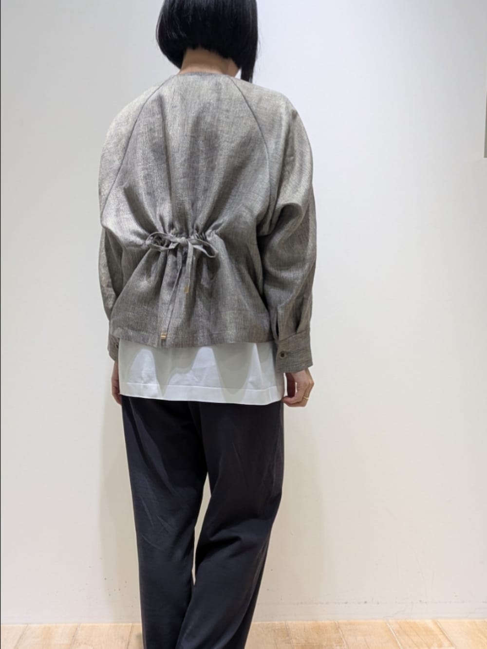 ベージュ系のブルゾン、グレー系のその他パンツ、ホワイト系のニット/セーターを着用したレディースの春コーディネートの5枚目の写真