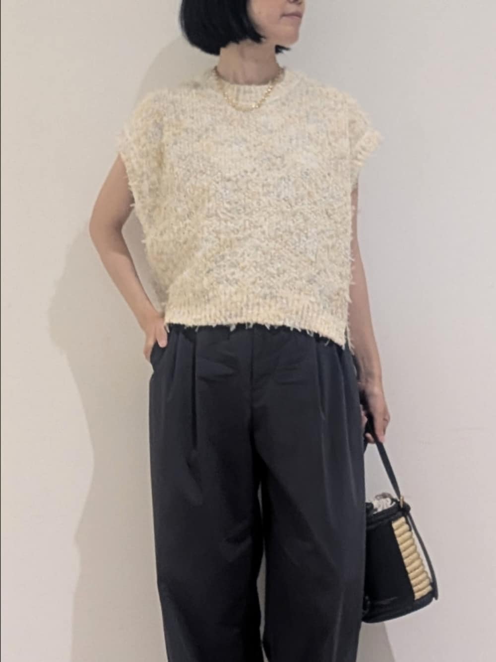ホワイト系のニット/セーター、グレー系のその他パンツ、ゴールド系のネックレスを着用したレディースの夏コーディネートの2枚目の写真