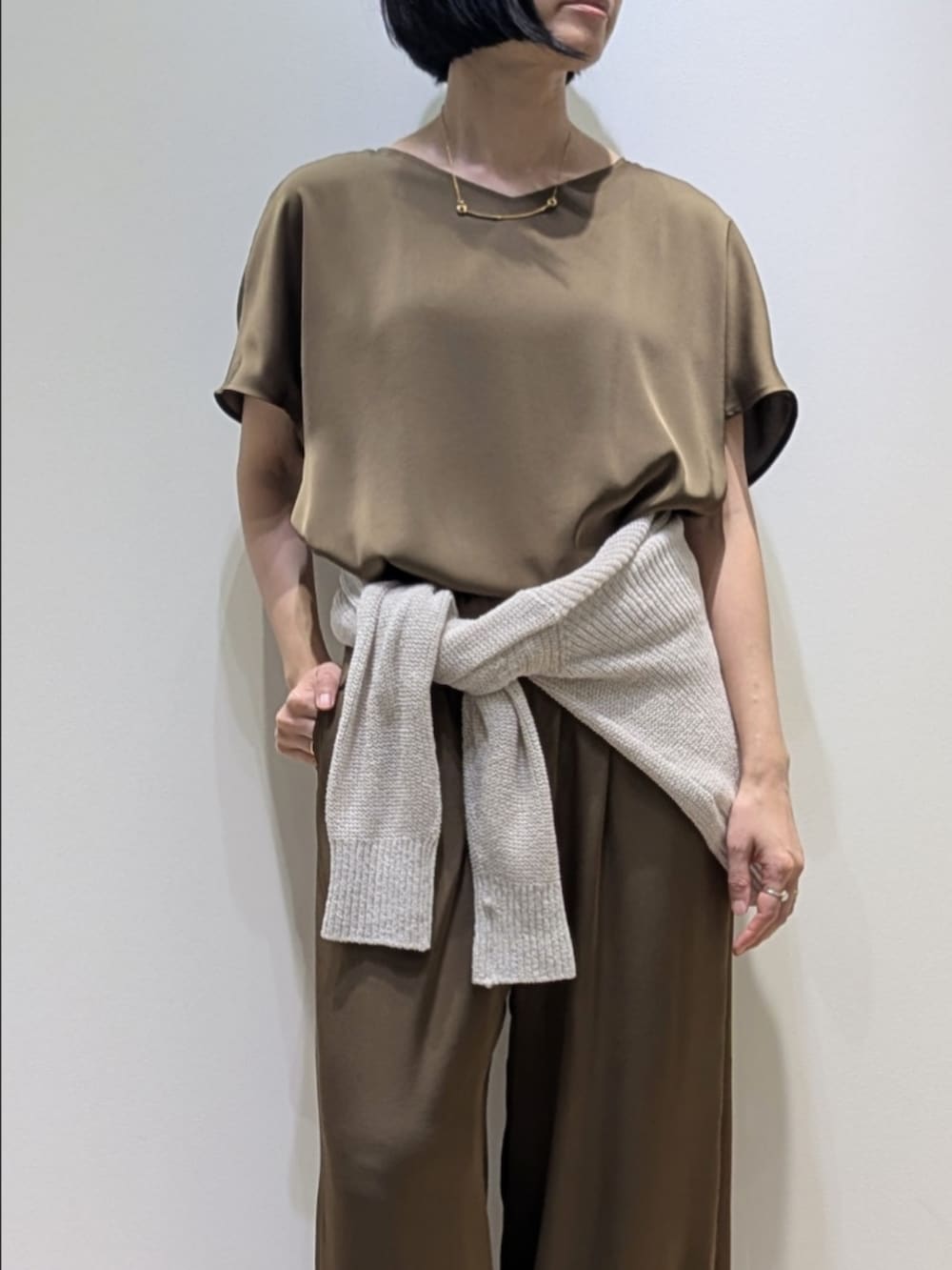 グリーン系のシャツ/ブラウス、グリーン系のその他パンツ、ベージュ系のニット/セーターを着用したレディースの春コーディネートの2枚目の写真