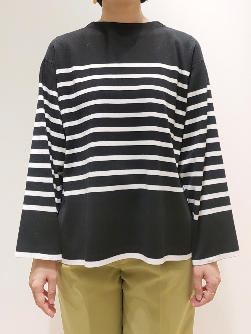 ブラック系のニット/セーター、イエロー系のスラックスを着用したレディースの冬コーディネートの2枚目の写真