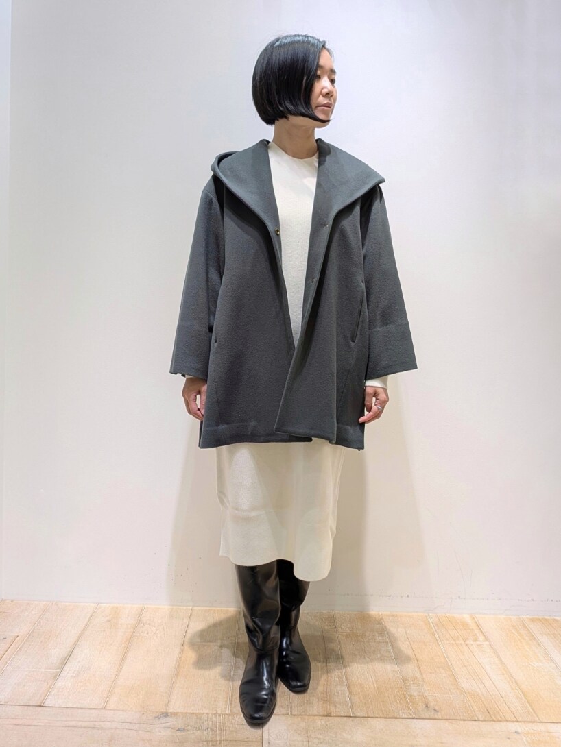 グリーン系のノーカラーコート、ホワイト系のワンピースを着用したレディースの冬コーディネートの4枚目の写真