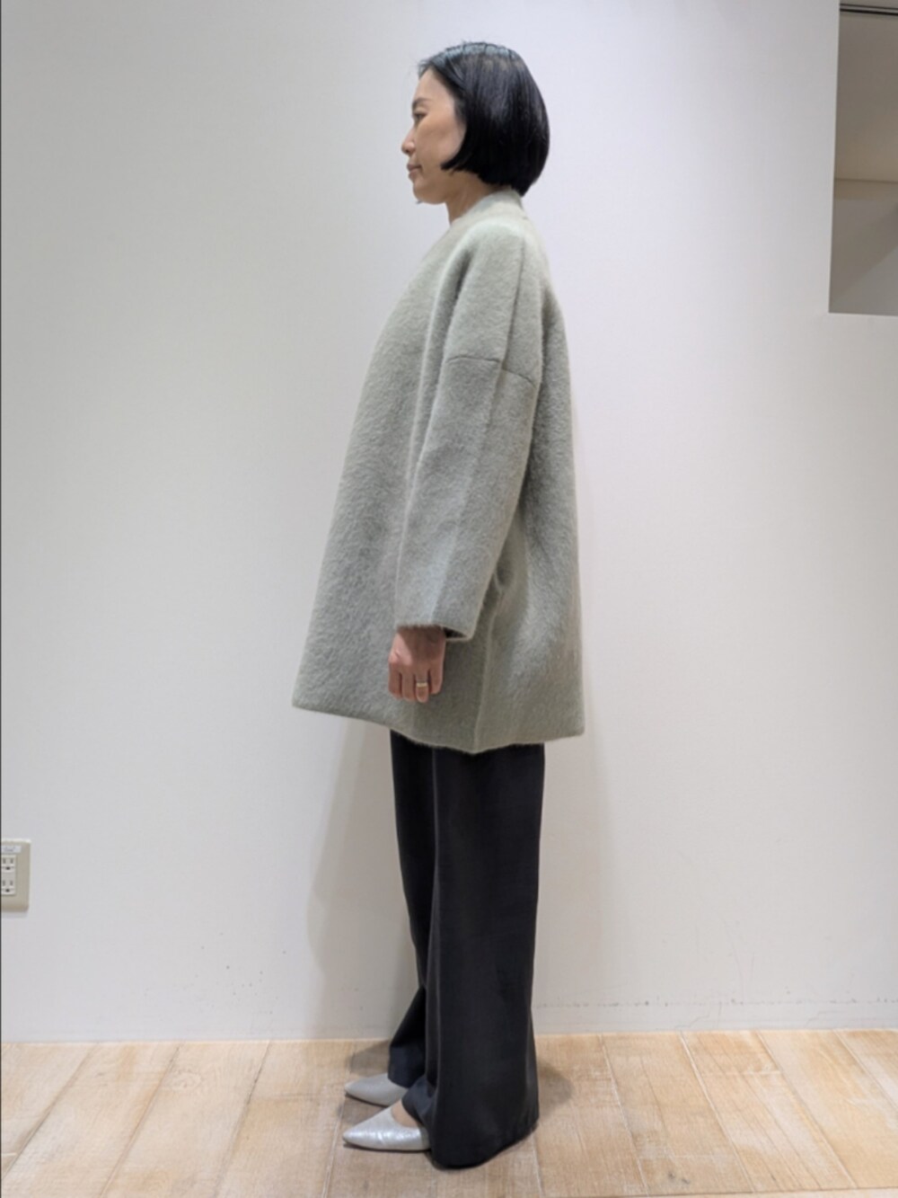 グリーン系のカーディガン/ボレロ、ホワイト系のシャツ/ブラウス、グレー系のその他パンツを着用したレディースの秋コーディネートの4枚目の写真