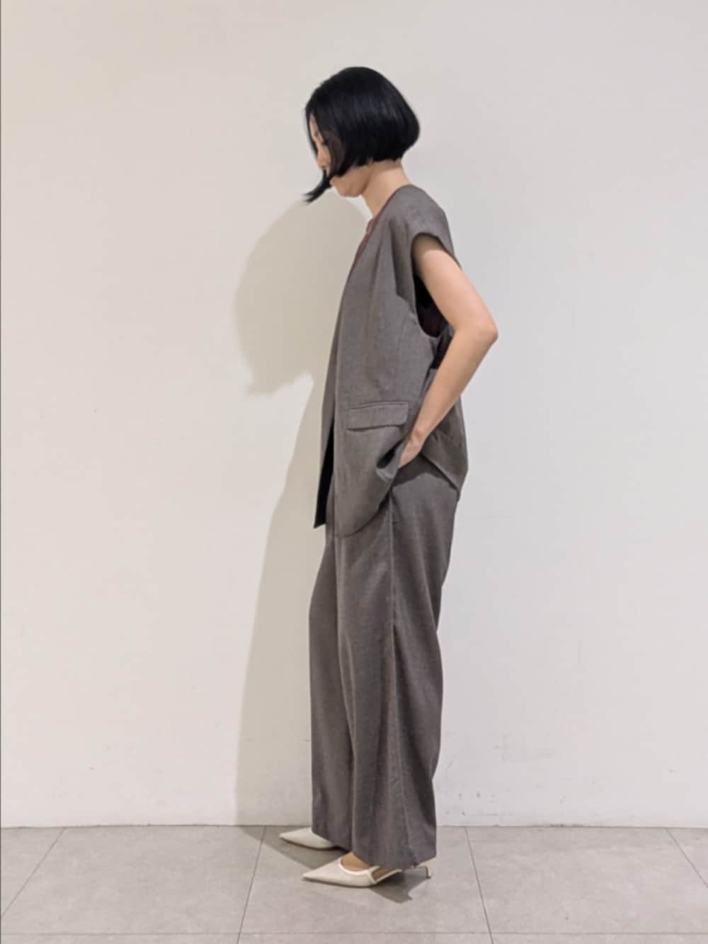 グレー系のベスト、グレー系のその他パンツ、レッド系のニット/セーターを着用したレディースの秋コーディネートの4枚目の写真