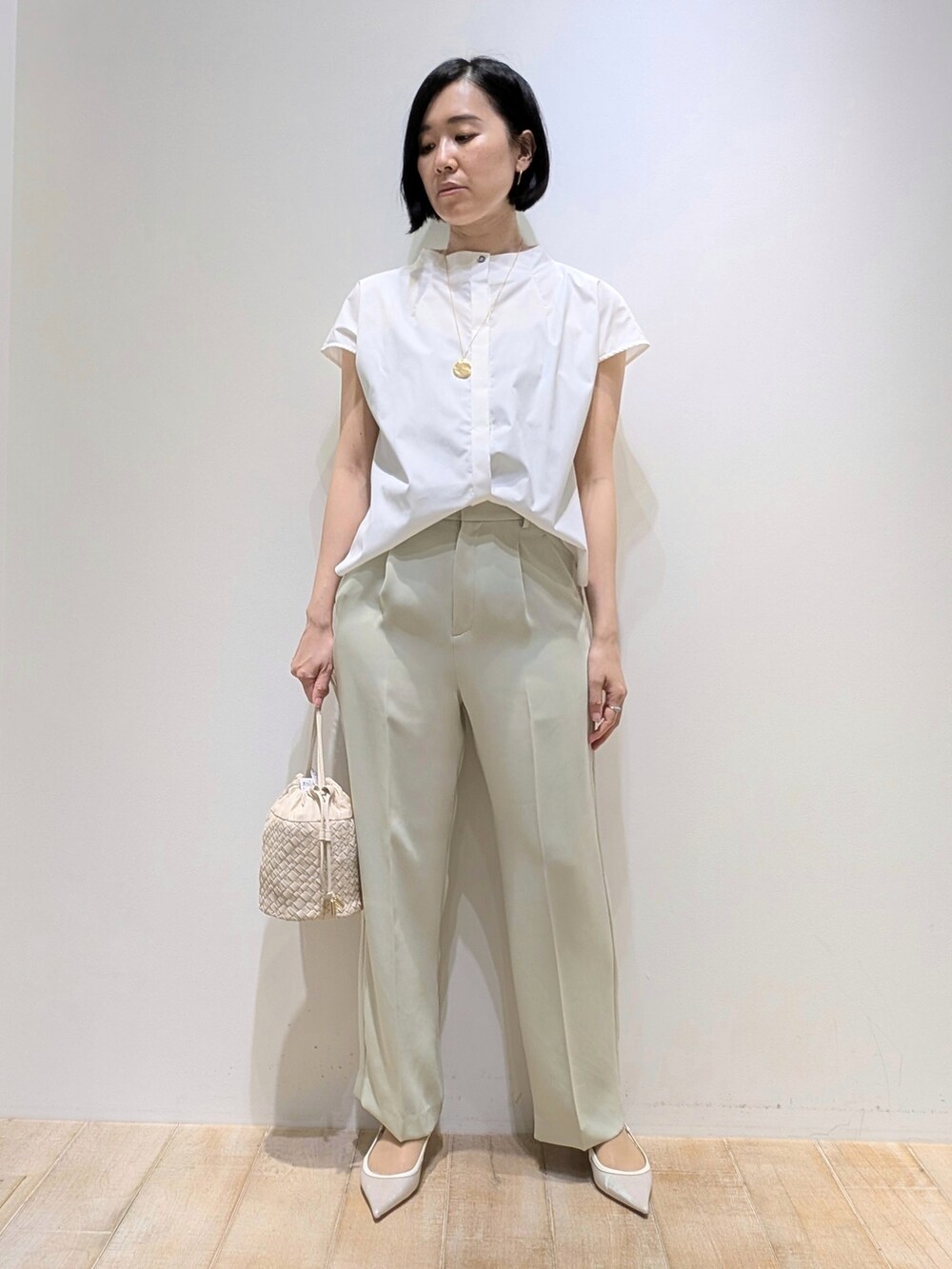グリーン系のスラックス、ホワイト系のシャツ/ブラウスを着用したレディースの夏コーディネートの2枚目の写真