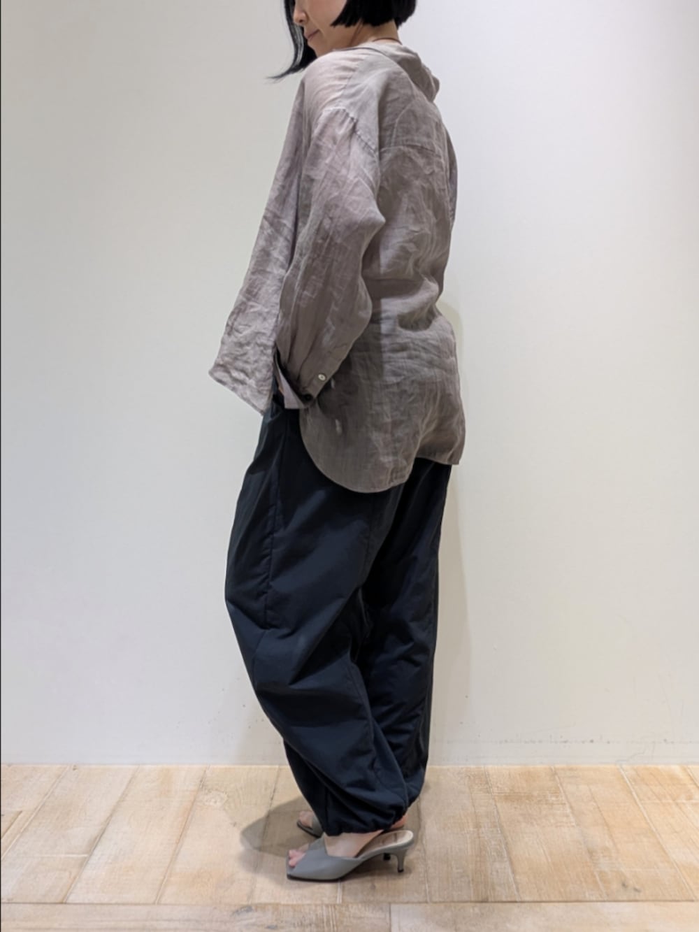 ブラウン系のシャツ/ブラウス、グレー系のその他パンツ、ゴールド系のネックレスを着用したレディースの春コーディネートの4枚目の写真