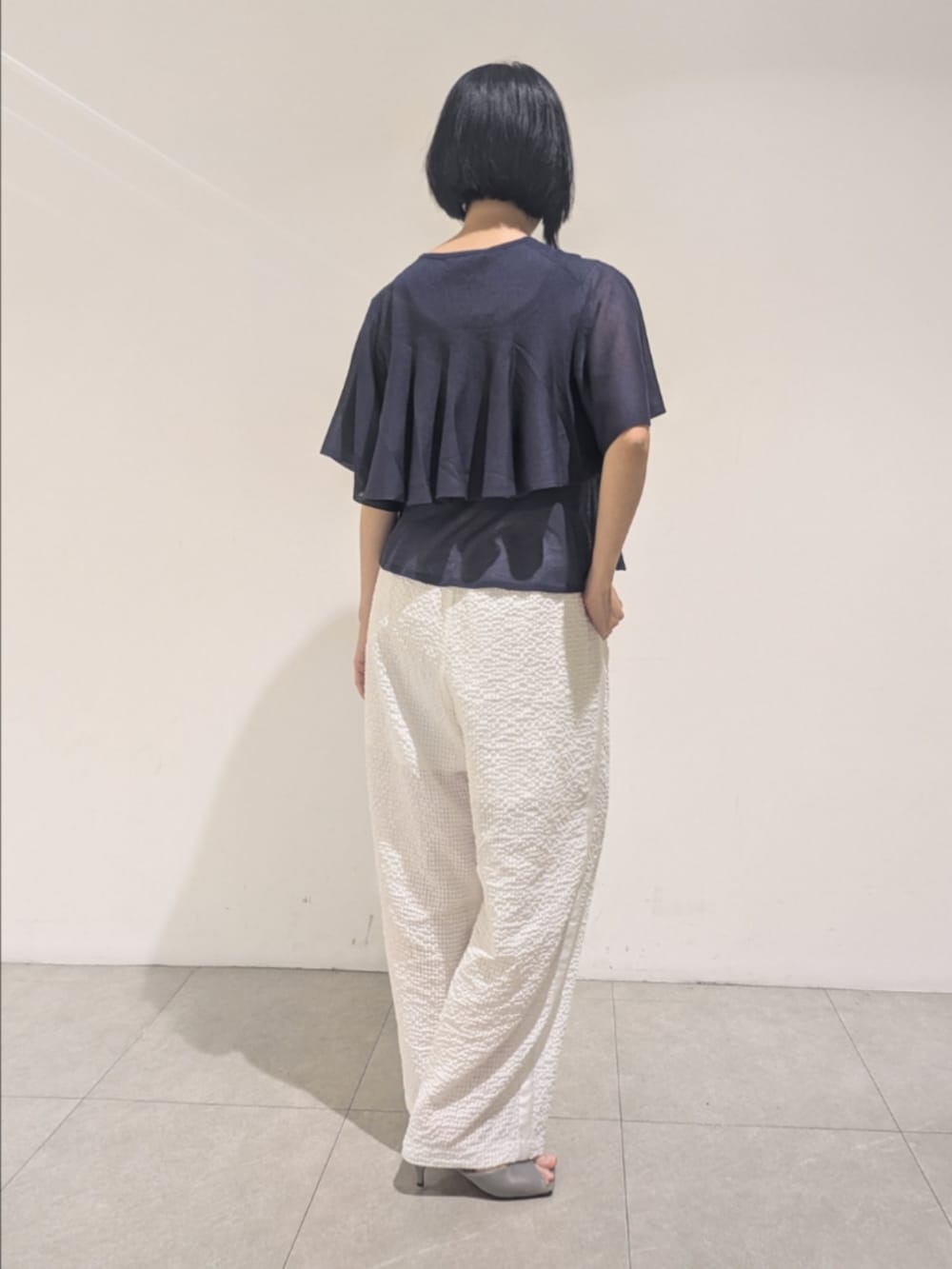 ブルー系のニット/セーター、ホワイト系のその他パンツ、シルバー系のネックレスを着用したレディースの夏コーディネートの5枚目の写真