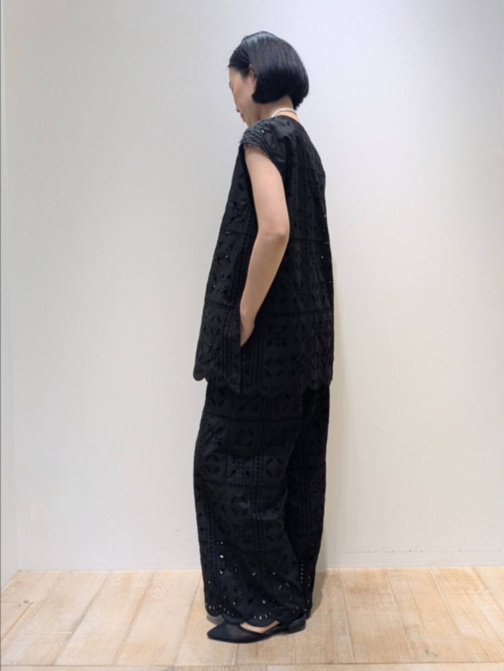ブラック系のシャツ/ブラウス、ブラック系のその他パンツ、ホワイト系のネックレスを着用したレディースの夏コーディネートの4枚目の写真