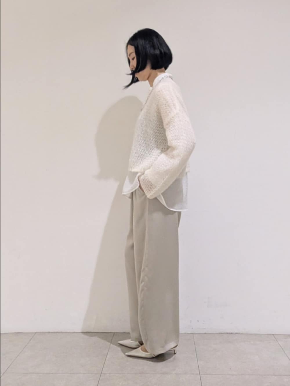 ホワイト系のニット/セーター、ホワイト系のシャツ/ブラウス、ベージュ系のその他パンツを着用したレディースの秋コーディネートの4枚目の写真