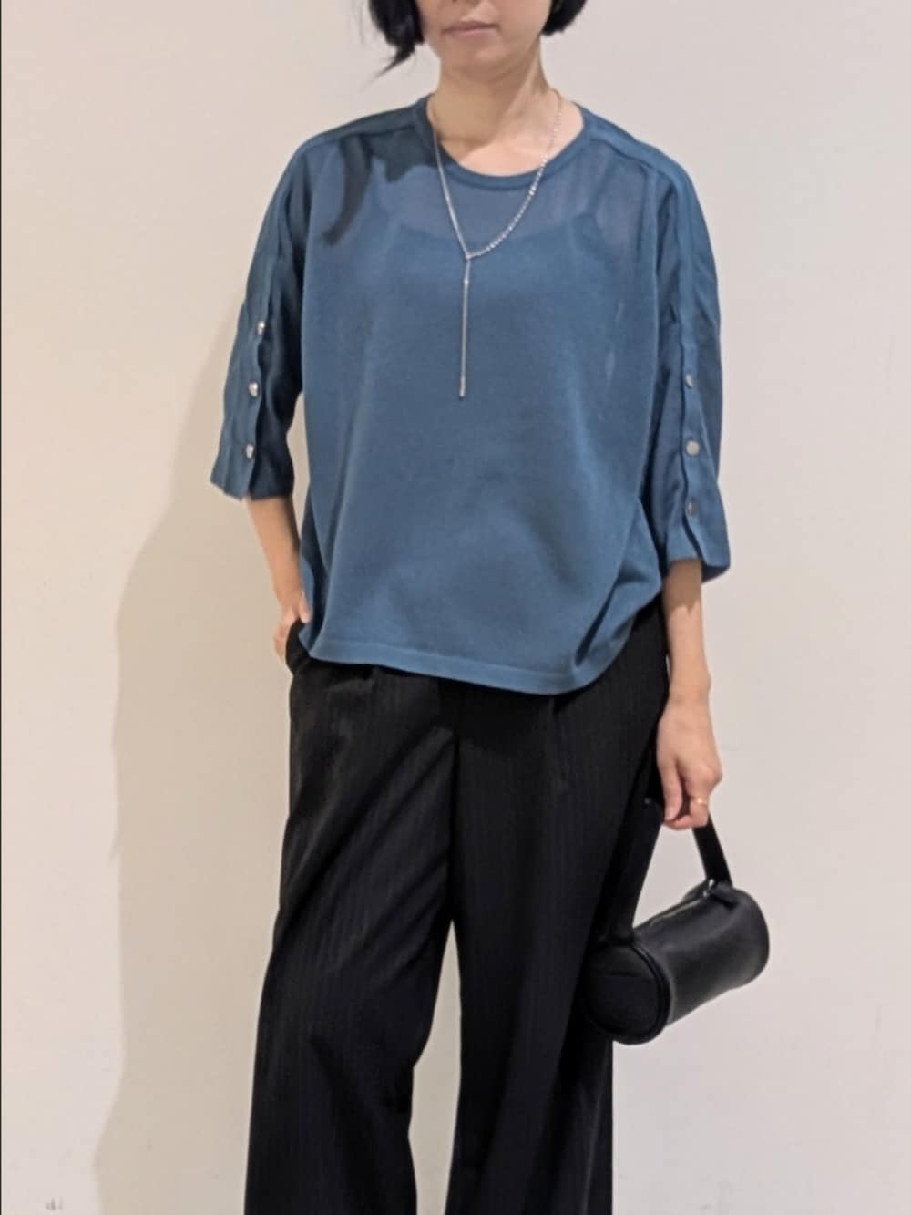 ブルー系のニット/セーター、ブラック系のその他パンツ、シルバー系のネックレスを着用したレディースの秋コーディネートの2枚目の写真