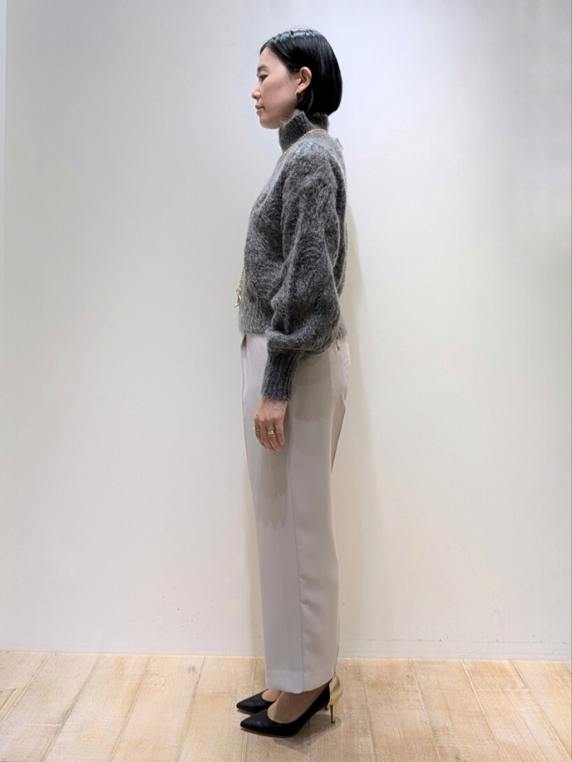 グレー系のニット/セーター、ピンク系のスラックスを着用したレディースの冬コーディネートの2枚目の写真