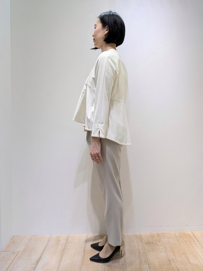 ホワイト系のシャツ/ブラウス、ベージュ系のスラックスを着用したレディースの冬コーディネートの2枚目の写真