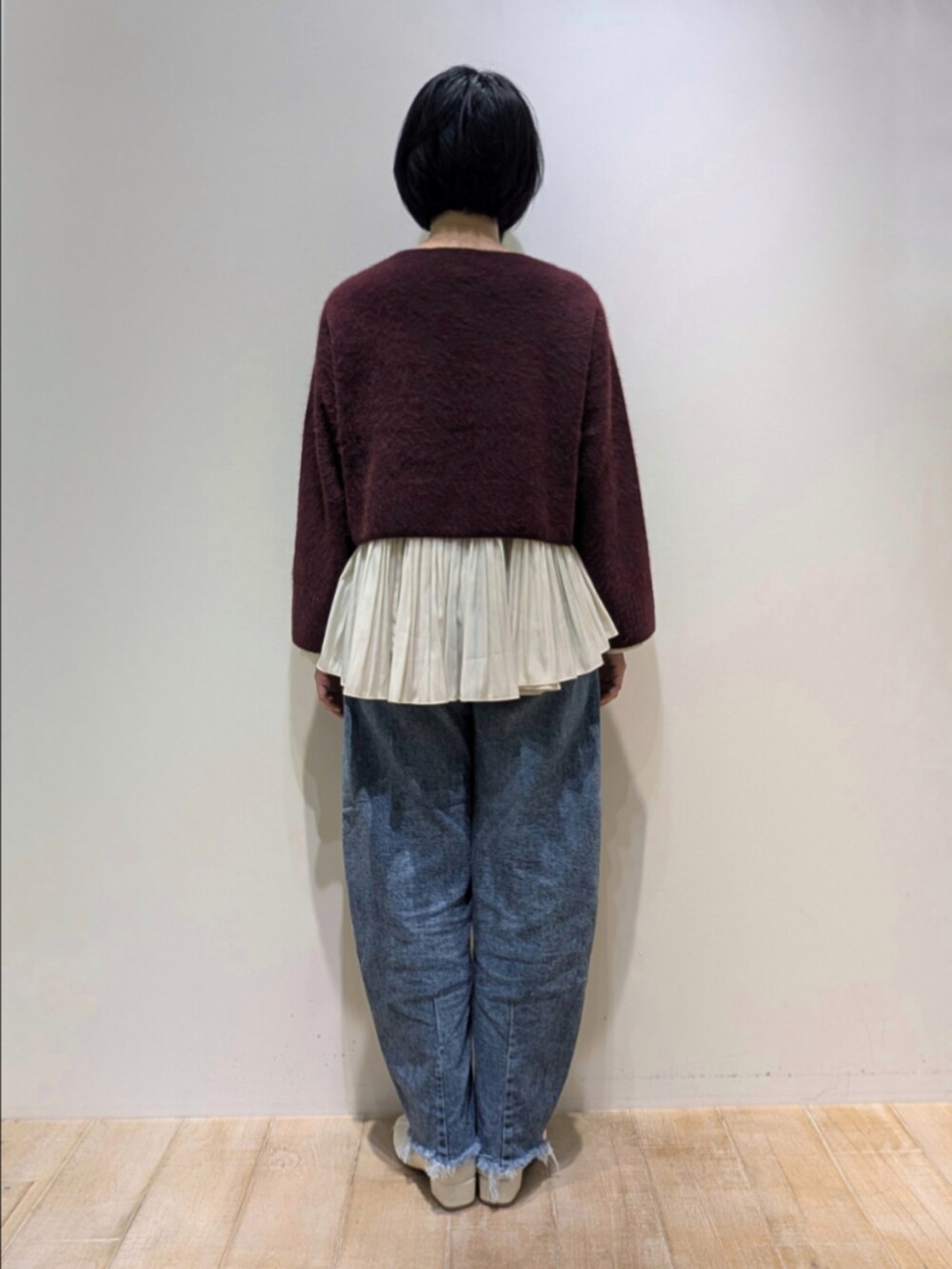 レッド系のニット/セーター、ホワイト系のシャツ/ブラウスを着用したレディースの冬コーディネートの5枚目の写真