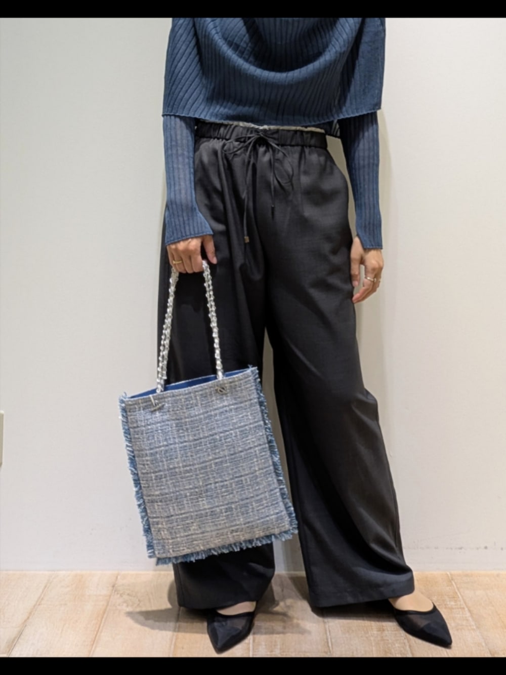 ブルー系のニット/セーター、グレー系のその他パンツ、シルバー系のトートバッグを着用したレディースの秋コーディネートの3枚目の写真