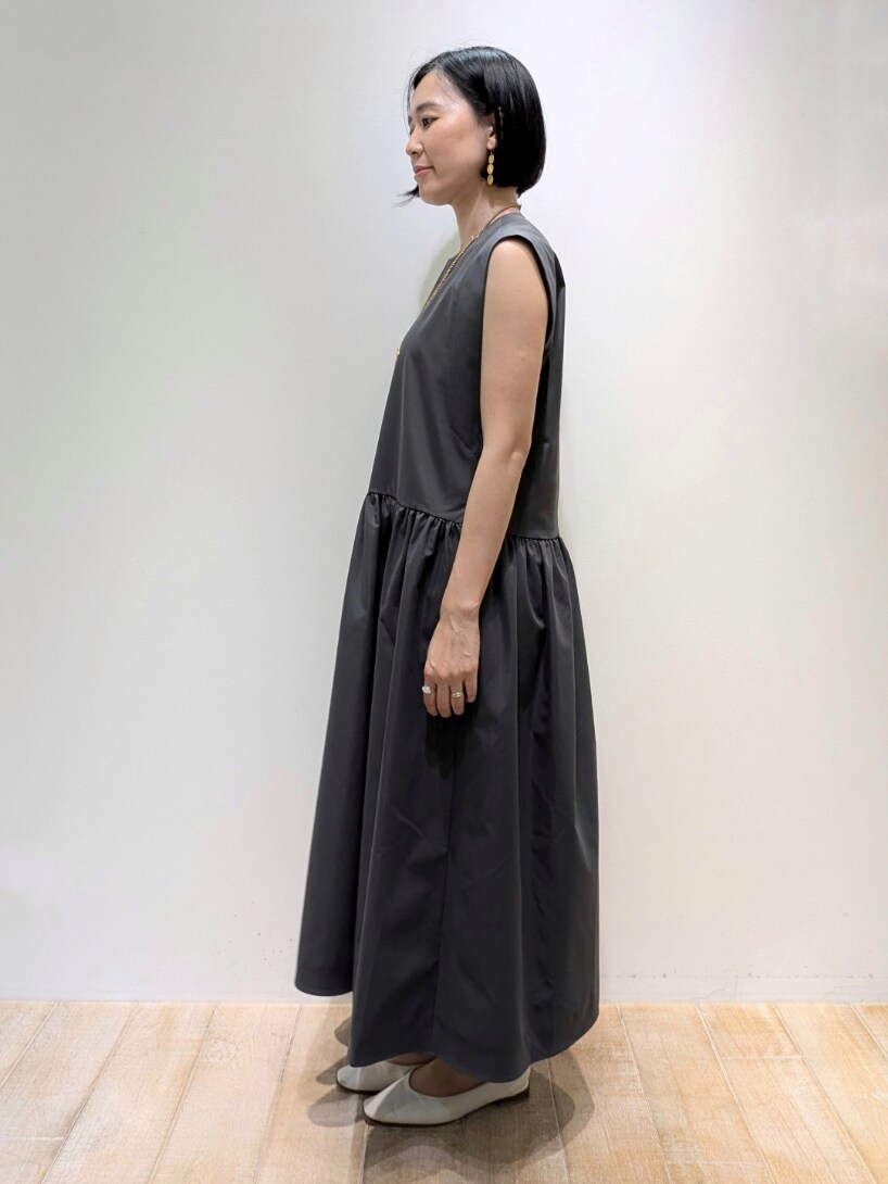 グレー系のワンピース、ゴールド系のネックレスを着用したレディースの夏コーディネートの3枚目の写真