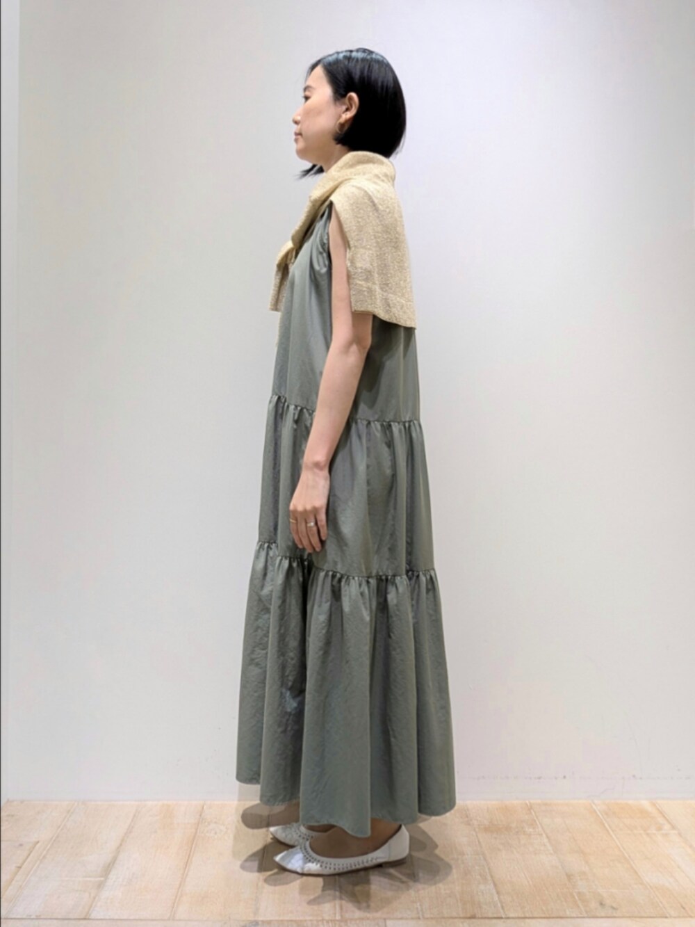 ゴールド系のTシャツ/カットソー、グリーン系のワンピース、ゴールド系のショルダーバッグを着用したレディースの夏コーディネートの2枚目の写真