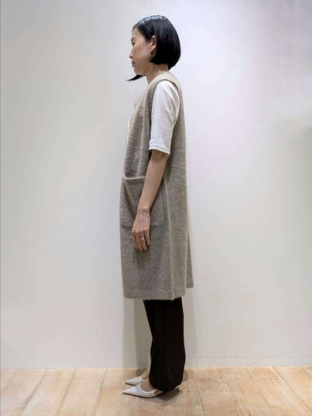 ホワイト系のTシャツ/カットソー、ブラウン系のベスト、ブラウン系のその他パンツを着用したレディースの秋コーディネートの4枚目の写真