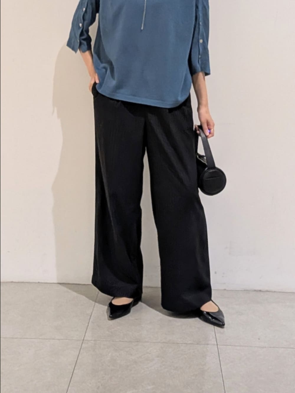 ブルー系のニット/セーター、ブラック系のその他パンツ、シルバー系のネックレスを着用したレディースの秋コーディネートの3枚目の写真