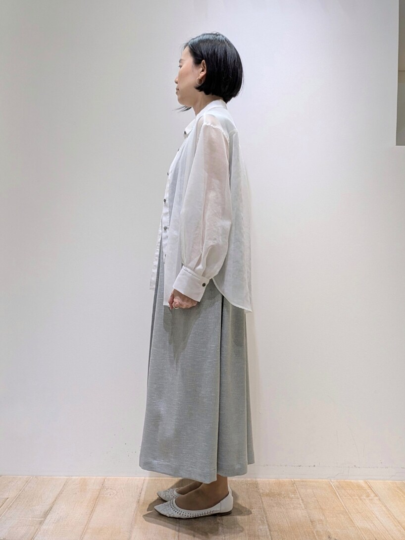 グリーン系のワンピース、ホワイト系のシャツ/ブラウスを着用したレディースの春コーディネートの2枚目の写真