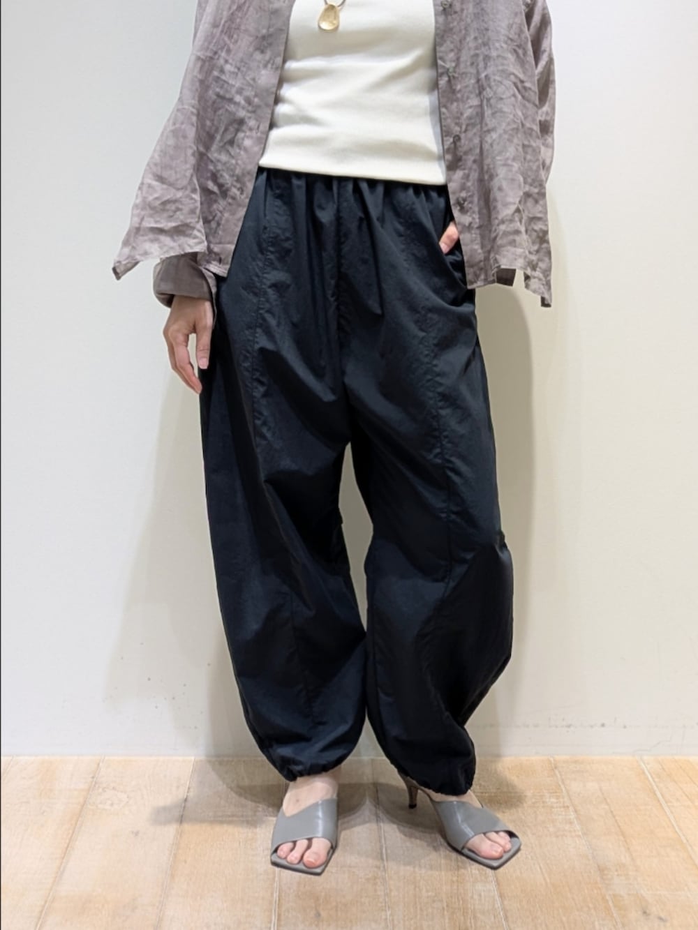 ブラウン系のシャツ/ブラウス、グレー系のその他パンツ、ゴールド系のネックレスを着用したレディースの春コーディネートの3枚目の写真