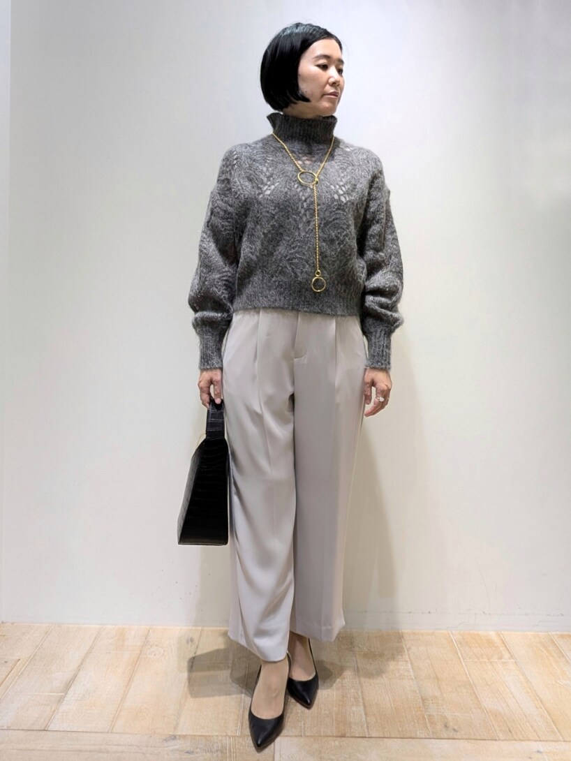 グレー系のニット/セーター、ピンク系のスラックスを着用したレディースの冬コーディネートの4枚目の写真