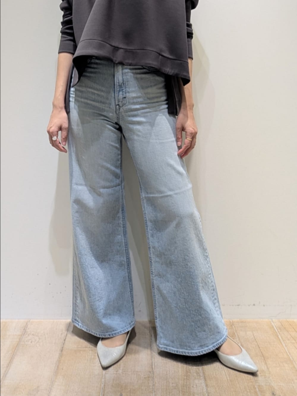 グレー系のスウェット、ブルー系のデニムパンツ、シルバー系のネックレスを着用したレディースの冬コーディネートの3枚目の写真