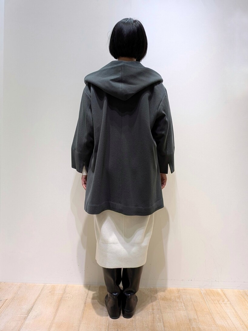 グリーン系のノーカラーコート、ホワイト系のワンピースを着用したレディースの冬コーディネートの3枚目の写真