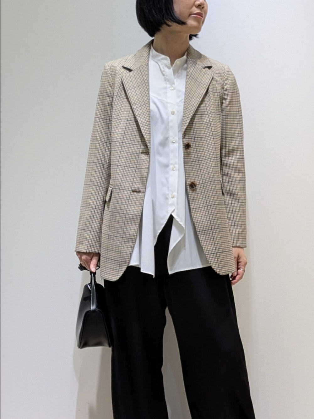 ベージュ系のテーラードジャケット、ホワイト系のシャツ/ブラウス、ブラック系のその他パンツを着用したレディースの秋コーディネートの2枚目の写真