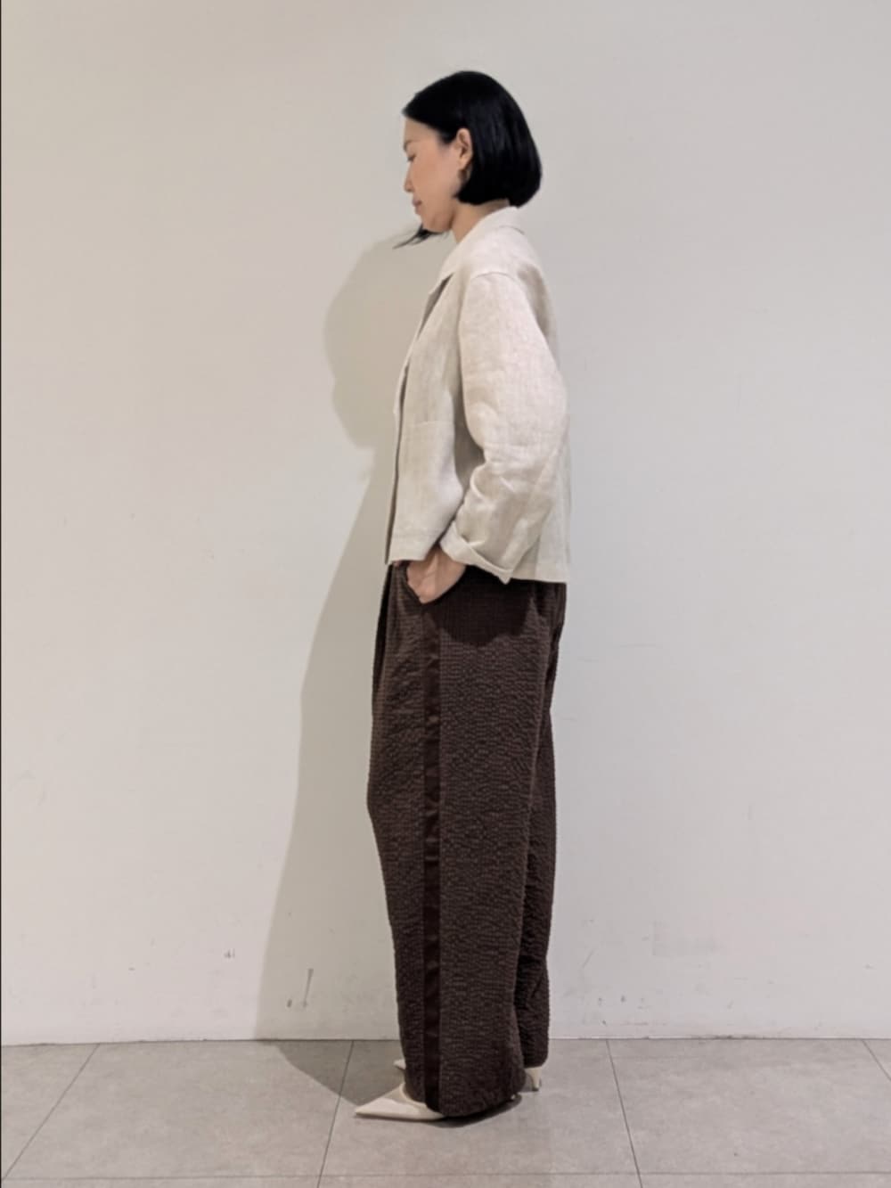 ベージュ系のテーラードジャケット、ブラウン系のその他パンツ、シルバー系のネックレスを着用したレディースの秋コーディネートの4枚目の写真