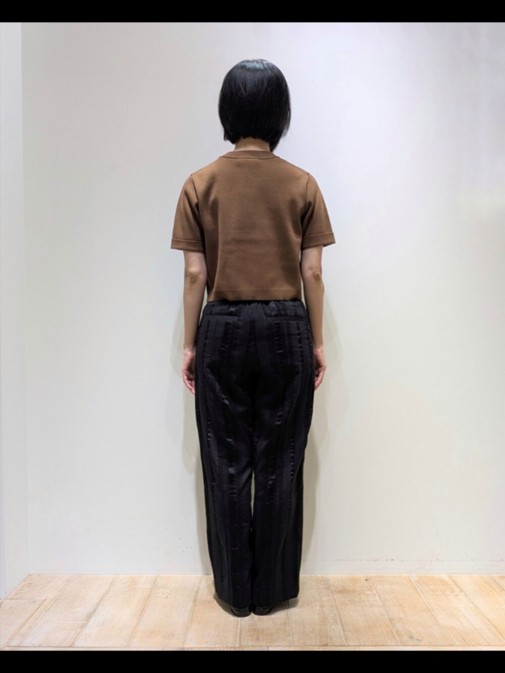 ブラウン系のTシャツ/カットソー、ブラック系のその他パンツ、ブラウン系のショルダーバッグを着用したレディースの秋コーディネートの5枚目の写真