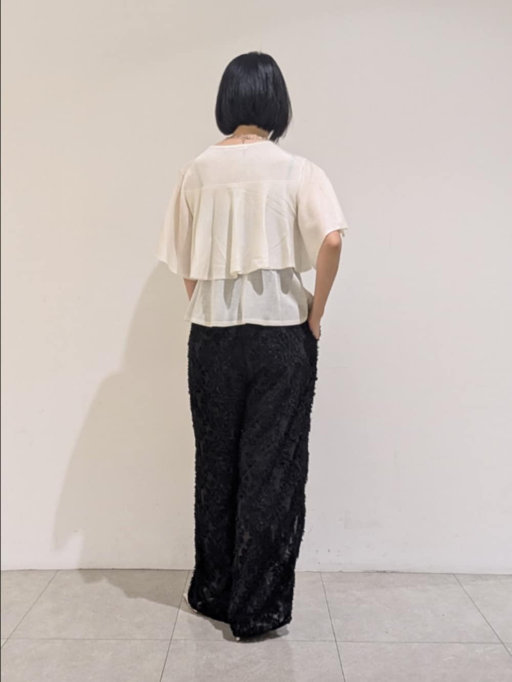 ホワイト系のニット/セーター、ブラック系のその他パンツを着用したレディースの夏コーディネートの5枚目の写真