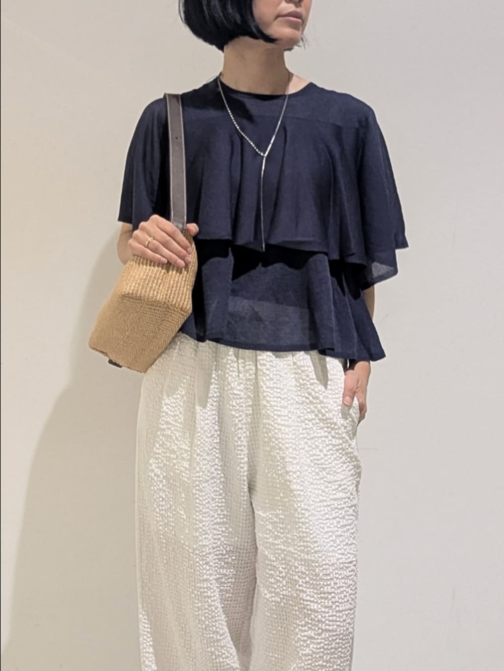 ブルー系のニット/セーター、ホワイト系のその他パンツ、シルバー系のネックレスを着用したレディースの夏コーディネートの2枚目の写真