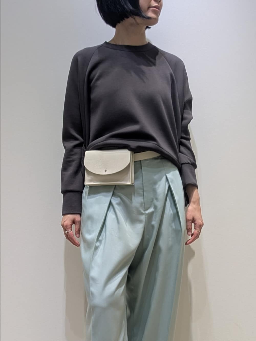 グリーン系のその他パンツ、グレー系のスウェット、ホワイト系のショルダーバッグを着用したレディースの冬コーディネートの2枚目の写真