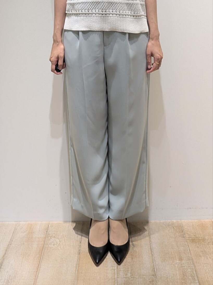 ホワイト系のニット/セーター、ブルー系のスラックスを着用したレディースの夏コーディネートの4枚目の写真