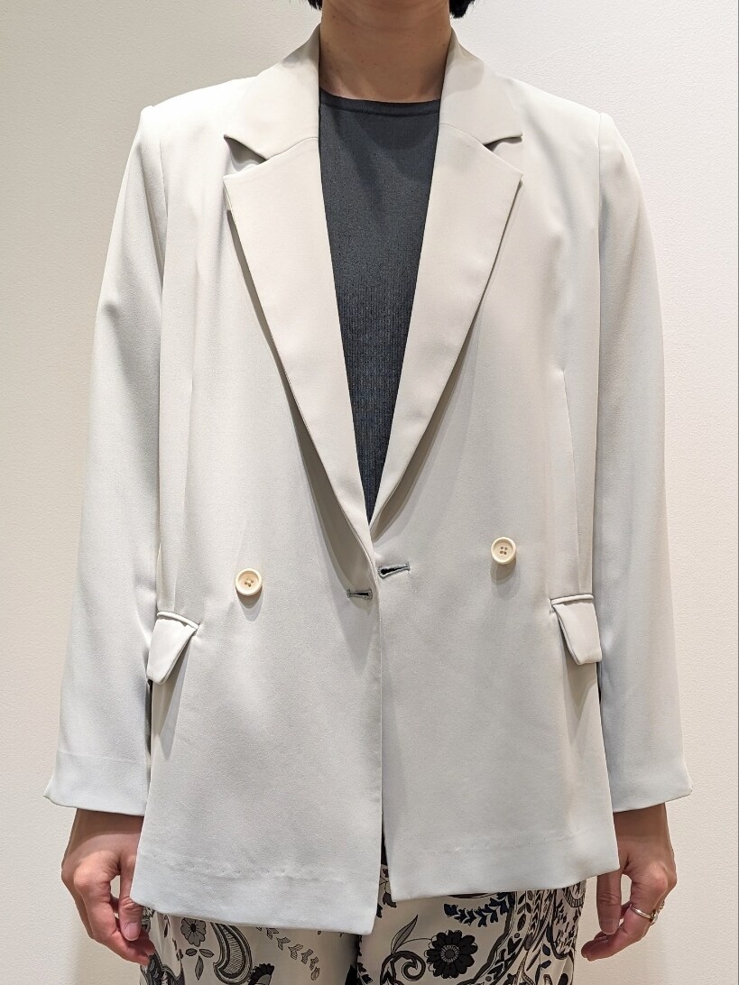 グリーン系のテーラードジャケット、グリーン系のニット/セーター、ブルー系のショルダーバッグを着用したレディースの春コーディネートの2枚目の写真