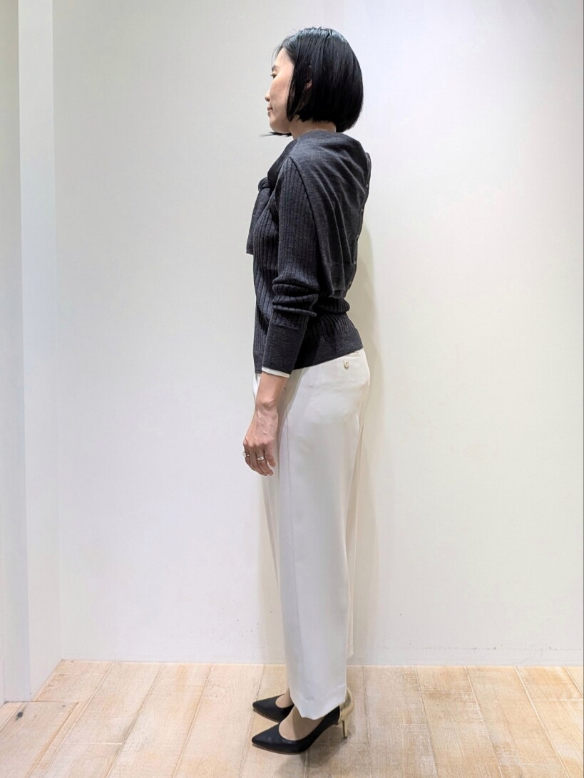 グレー系のニット/セーター、グレー系のカーディガン/ボレロ、ホワイト系のスラックスを着用したレディースの秋コーディネートの2枚目の写真