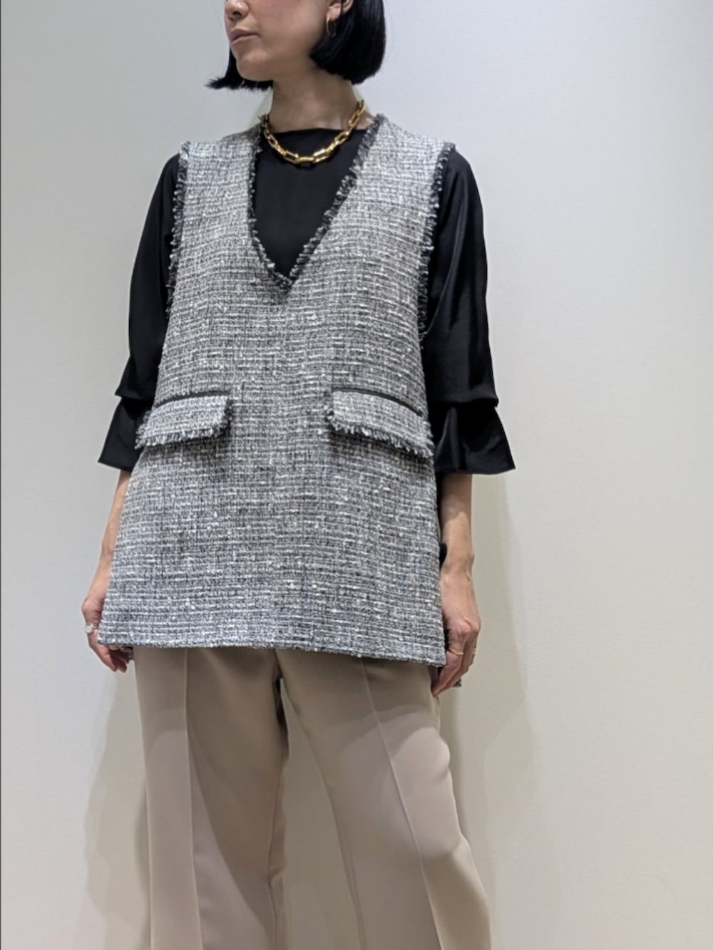 ブラック系のシャツ/ブラウス、ブラック系のベスト、ベージュ系のその他パンツを着用したレディースの冬コーディネートの2枚目の写真