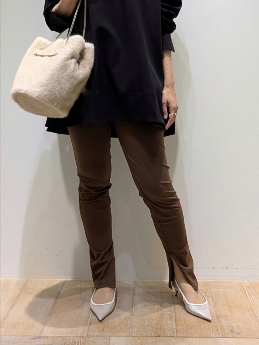 ブラック系のスウェット、ブラウン系のその他パンツ、ホワイト系のショルダーバッグを着用したレディースの秋コーディネートの3枚目の写真
