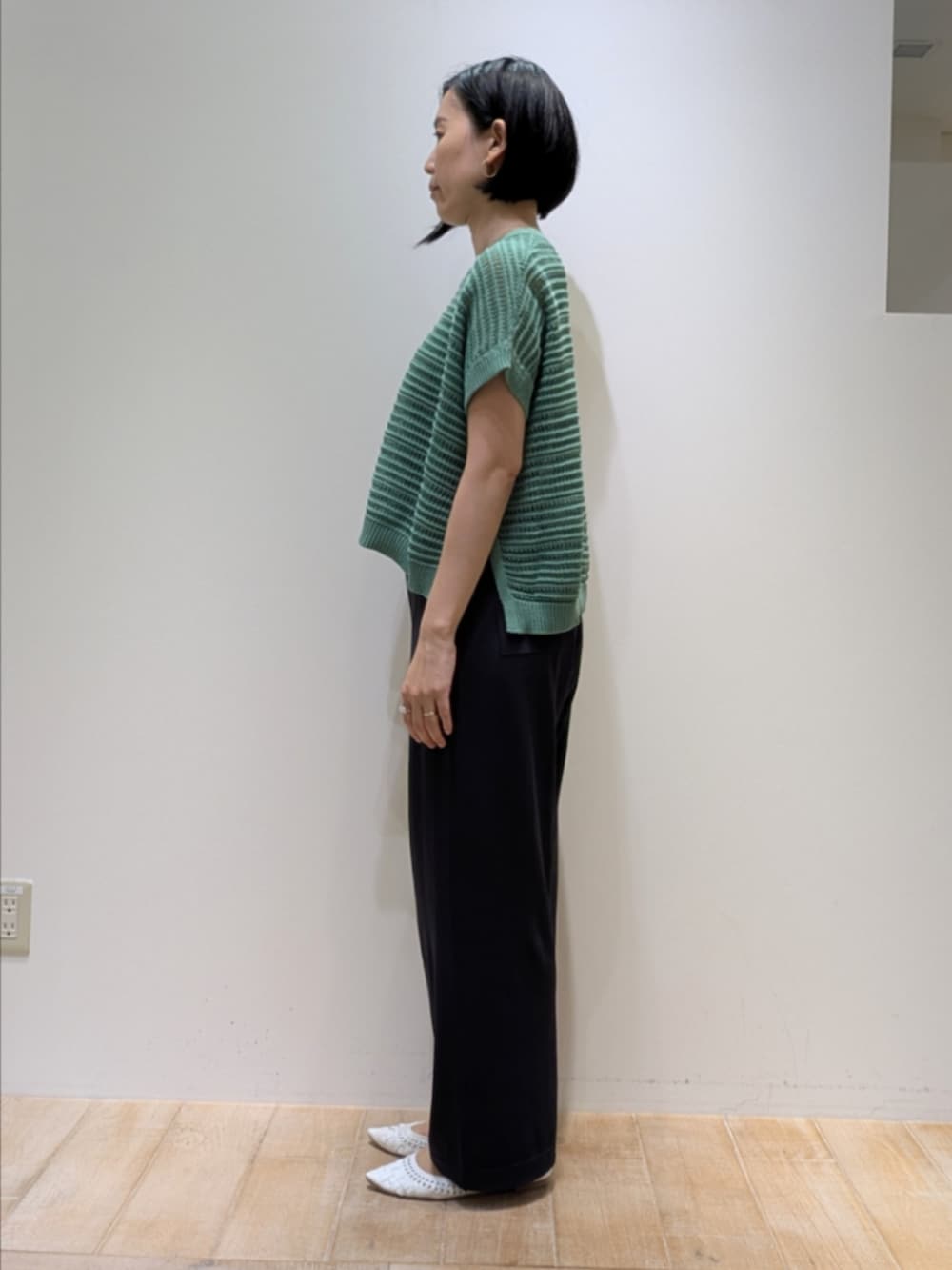 グリーン系のニット/セーター、グレー系のその他パンツを着用したレディースの夏コーディネートの3枚目の写真