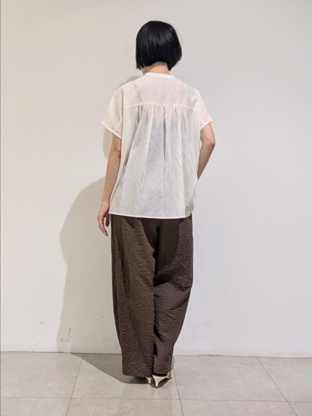 ホワイト系のシャツ/ブラウス、ブラウン系のその他パンツ、ゴールド系のネックレスを着用したレディースの夏コーディネートの5枚目の写真