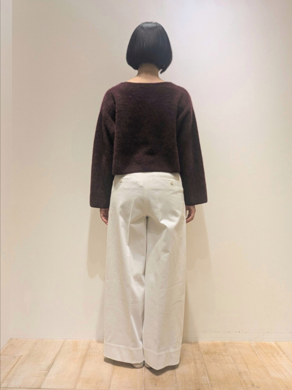 レッド系のニット/セーター、ホワイト系のデニムパンツを着用したレディースの冬コーディネートの5枚目の写真