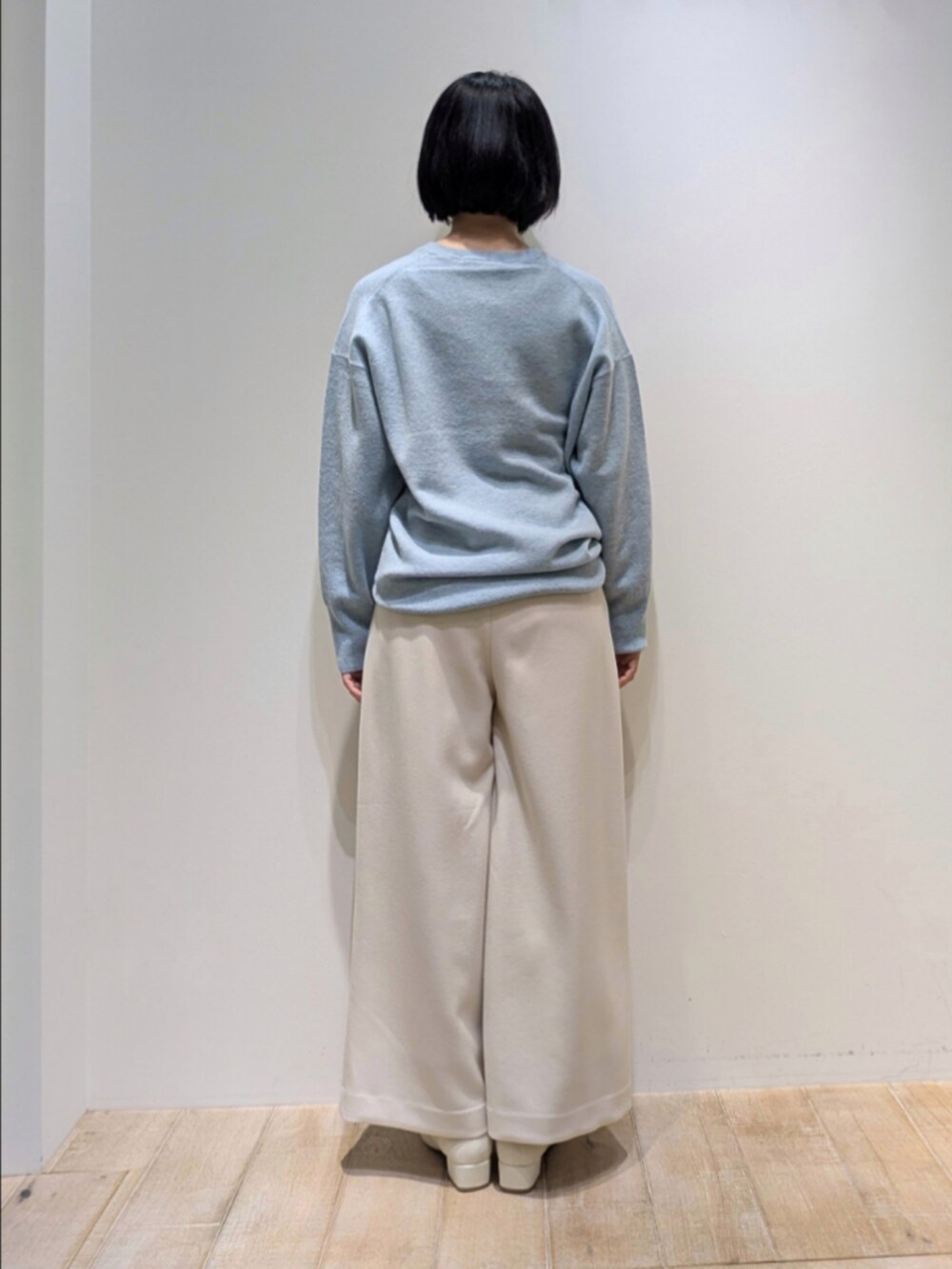 ブルー系のニット/セーター、ホワイト系のその他パンツを着用したレディースの冬コーディネートの5枚目の写真