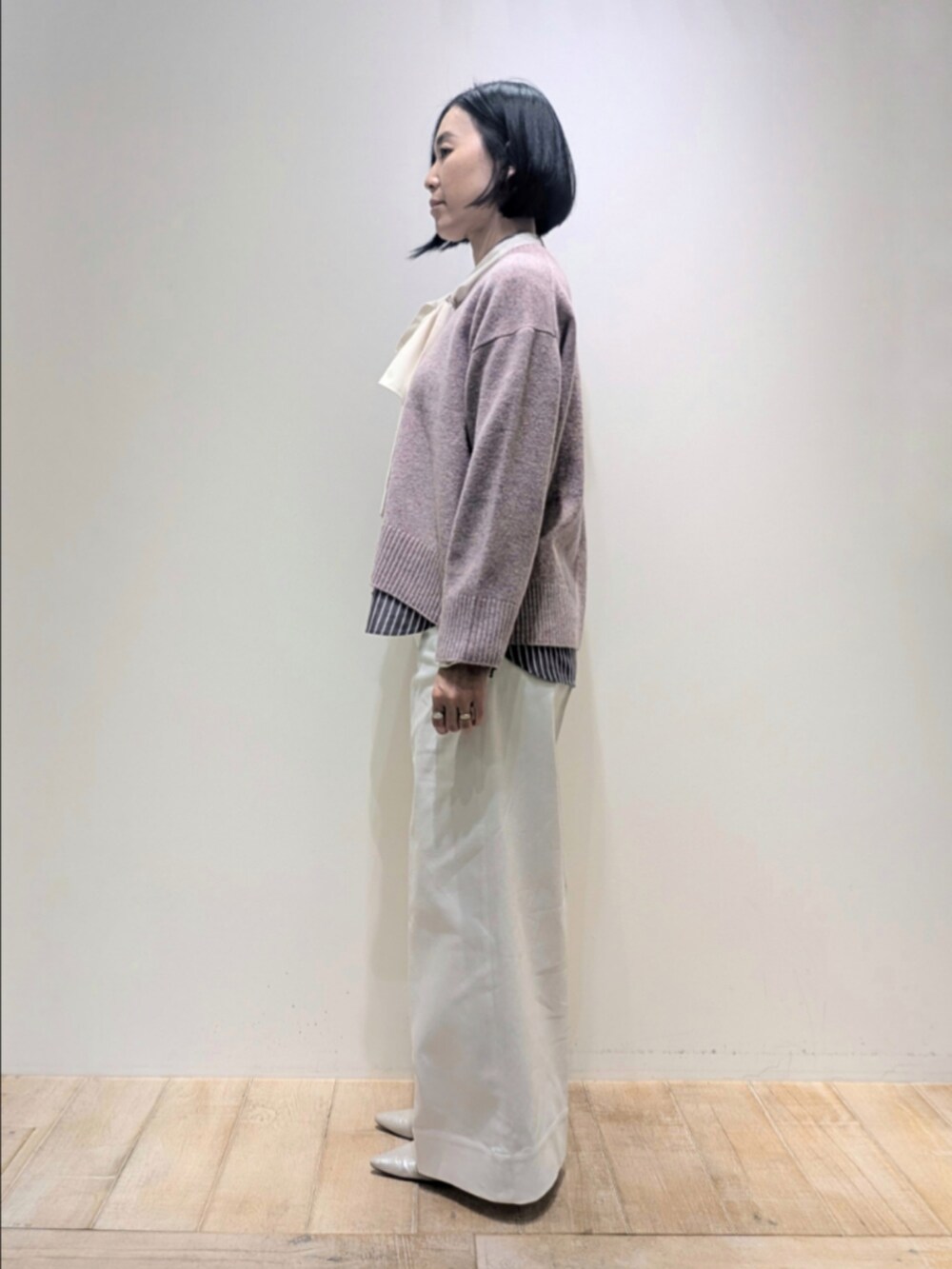 ピンク系のニット/セーター、ブラック系のシャツ/ブラウス、ホワイト系のデニムパンツを着用したレディースの冬コーディネートの4枚目の写真