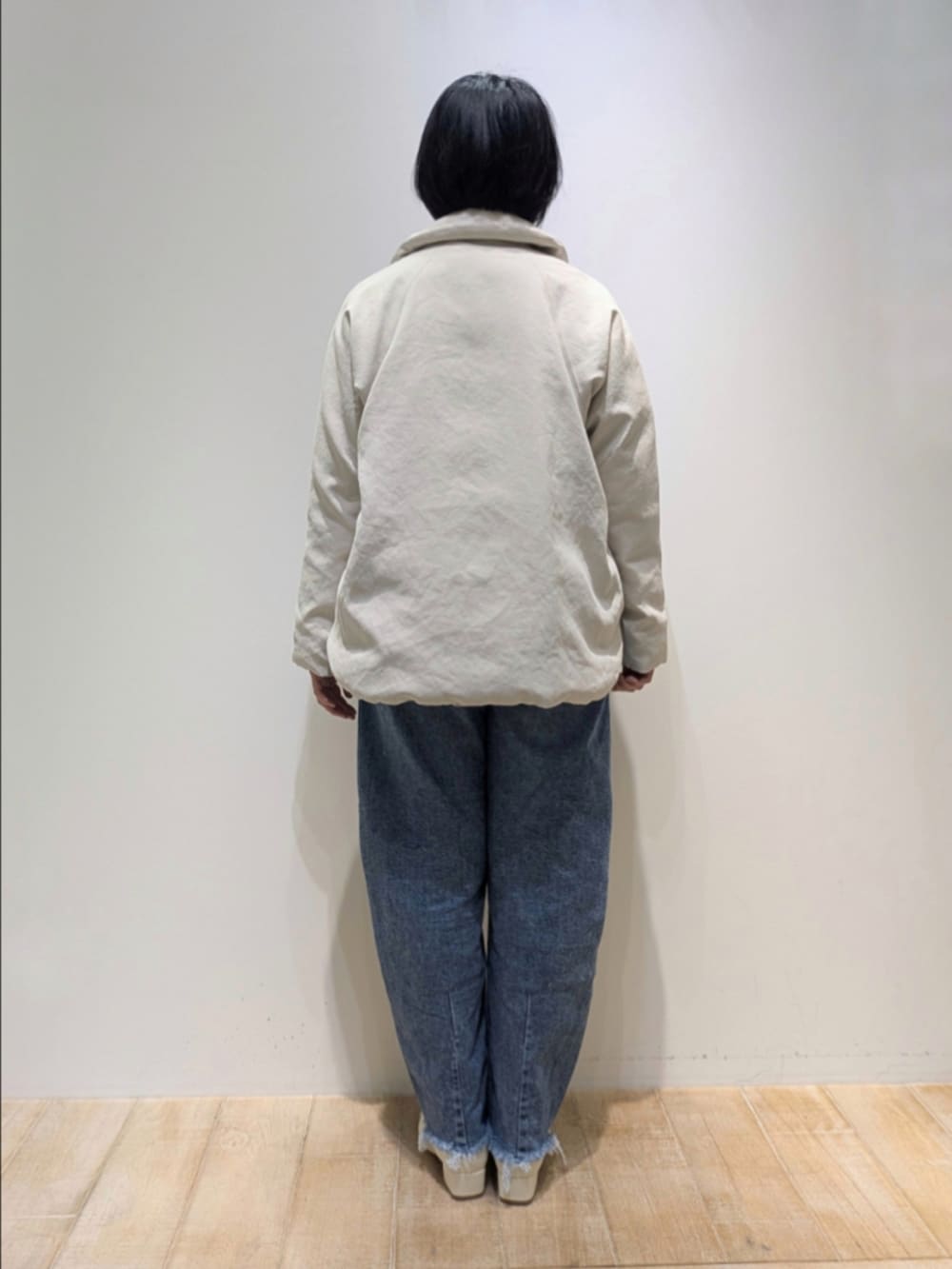 ベージュ系のダウンジャケット/コート、レッド系のニット/セーター、ホワイト系のシャツ/ブラウスを着用したレディースの秋コーディネートの5枚目の写真