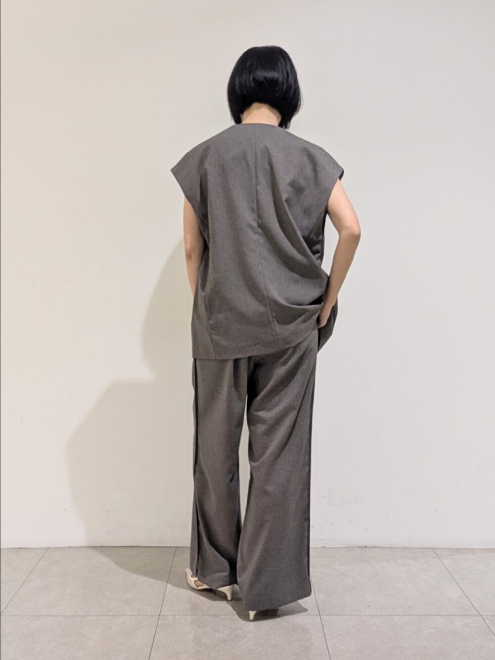 グレー系のベスト、グレー系のその他パンツ、レッド系のニット/セーターを着用したレディースの秋コーディネートの5枚目の写真